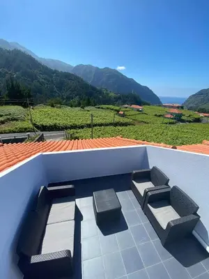a patio with two seats and a view of a mountain at Sebastian's Apartment in São Vicente