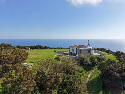 an aerial view of a house on a hill next to the ocean at Casita - Cantinho do Paraíso in Vila do Porto