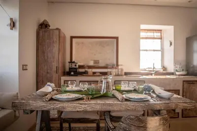 a table with glasses and plates on it in a kitchen at Casita - Cantinho do Paraíso in Vila do Porto