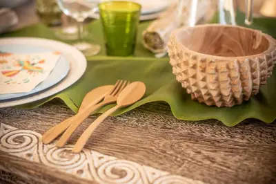 a table with wooden utensils on a green table cloth at Casita - Cantinho do Paraíso in Vila do Porto