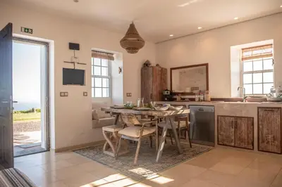 a kitchen with a table and a dining room with a view at Casita - Cantinho do Paraíso in Vila do Porto