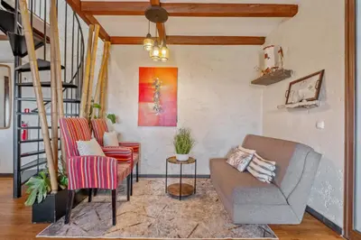a living room with two chairs and a staircase at São Jorge Cottage - By WeHost in Santana