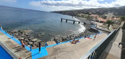 a group of people on a beach near the water at Apartamento T2-5m Aeroporto CR7 in Santa Cruz