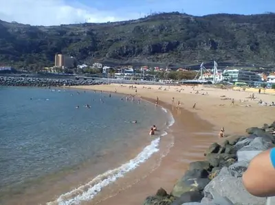 a beach with a bunch of people in the water at Apartamento T2-5m Aeroporto CR7 in Santa Cruz