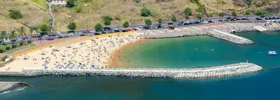 a beach with a bunch of people in the water at Apartamento T2-5m Aeroporto CR7 in Santa Cruz