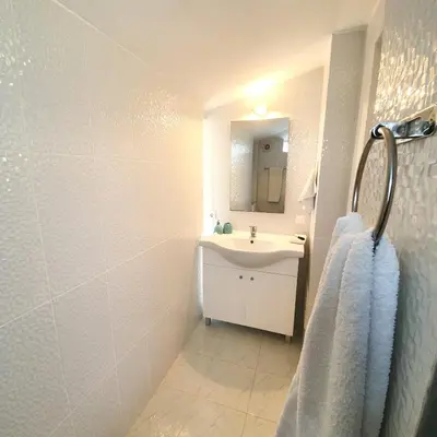 a white bathroom with a sink and a mirror at Seaside Studio in Sagres - 38 sqm with Terrace and Garden in Sagres