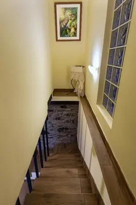 a hallway with a staircase with two windows at Villa Rústica - Casa da Lurdes in Ribeira Brava