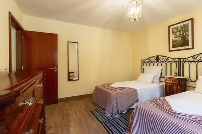a bedroom with a bed and a tv and a window at Villa Rústica - Casa da Lurdes in Ribeira Brava