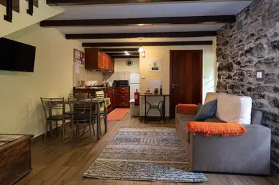 a living room with a couch and a stone wall at Villa Rústica - Casa da Lurdes in Ribeira Brava