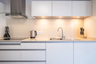 a kitchen with white cabinets and a sink at SolMar in Jardim do Mar