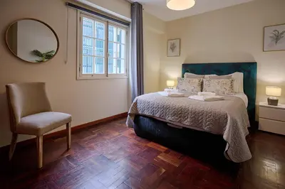 a bedroom with a bed and a chair and a mirror at Mon Coin Dans La Ville by Homie in Funchal
