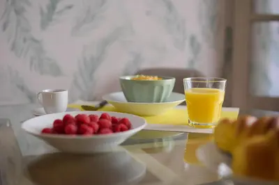 a table with a bowl of fruit and a glass of orange juice at Mon Coin Dans La Ville by Homie in Funchal