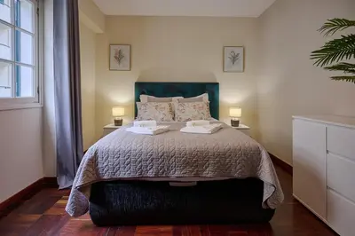 a bedroom with a bed with two lamps on two tables at Mon Coin Dans La Ville by Homie in Funchal