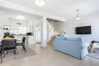 a living room with a blue couch and a table at Newly renovated 2 bedroom townhouse - close to Salema Beach in Salema