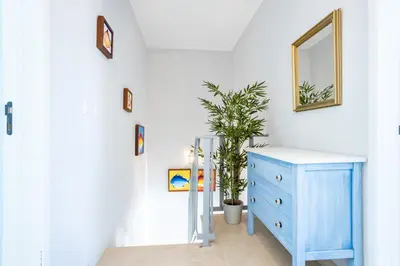 a room with a blue dresser and a mirror at Newly renovated 2 bedroom townhouse - close to Salema Beach in Salema