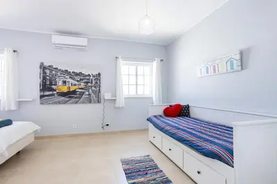 a bedroom with a bed and a painting on the wall at Newly renovated 2 bedroom townhouse - close to Salema Beach in Salema