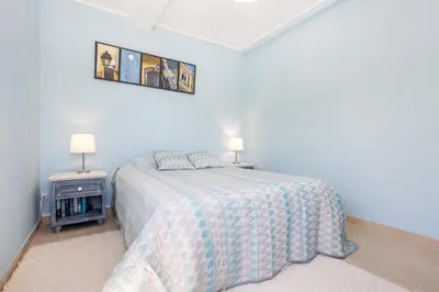 a white bedroom with a bed and two lamps at Newly renovated 2 bedroom townhouse - close to Salema Beach in Salema