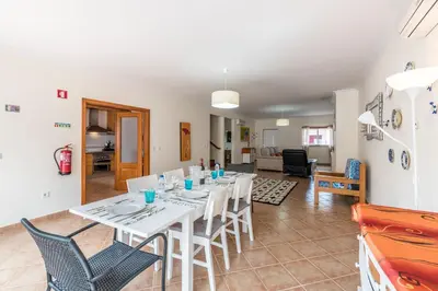 a dining room and living room with a table and chairs at Casa dos Sonhos in Luz