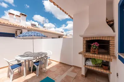 a balcony with a table and a fireplace at Casa dos Sonhos in Luz