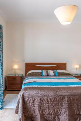 a bedroom with a bed and two night stands at Casa dos Sonhos in Luz