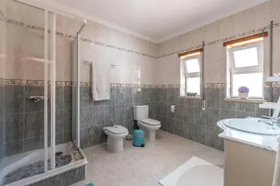 a bathroom with a toilet and a shower and a sink at Casa dos Sonhos in Luz