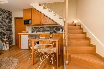 a kitchen with a table and stairs in a home at Cottage Pearl - Rural Holiday Experience by SeaPearl in Paul do Mar