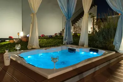 a jacuzzi tub with two wine glasses in it at Cottage Pearl - Rural Holiday Experience by SeaPearl in Paul do Mar