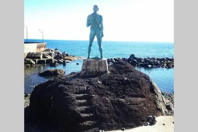 a statue of a man standing on a rock near the ocean at Cottage Pearl - Rural Holiday Experience by SeaPearl in Paul do Mar