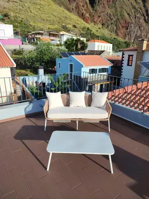 a white couch and a bench on a roof at Cottage Pearl - Rural Holiday Experience by SeaPearl in Paul do Mar