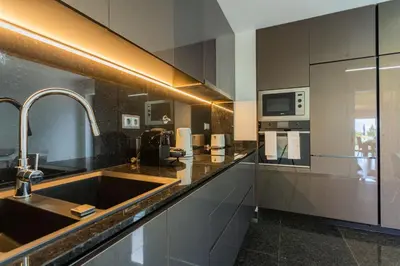 a kitchen with a sink and a microwave at FLH Funchal Balcony Flat with Pool in Funchal