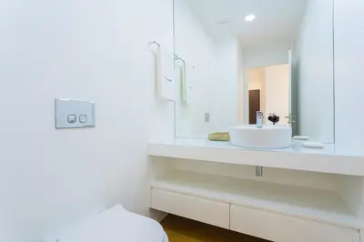 a white bathroom with a sink and a mirror at FLH Funchal Balcony Flat with Pool in Funchal