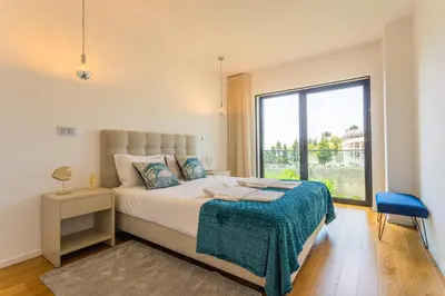a bedroom with a bed and a large window at FLH Funchal Balcony Flat with Pool in Funchal