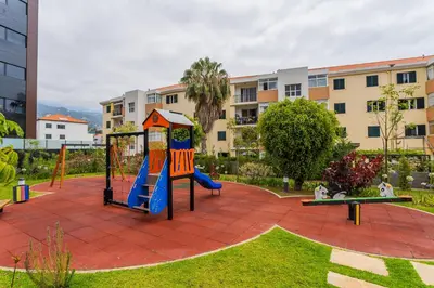 a playground in a park in front of a building at FLH Funchal Balcony Flat with Pool in Funchal