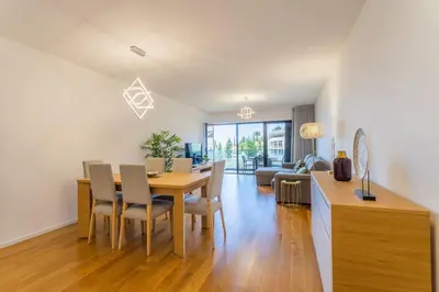 a dining room and living room with a table and chairs at FLH Funchal Balcony Flat with Pool in Funchal
