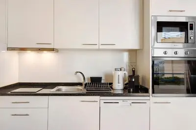 a kitchen with white cabinets and a sink at Ninho Gaivota in Porto Moniz