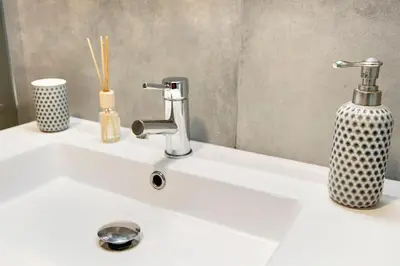 a bathroom sink with a faucet and a vase on it at Ninho Gaivota in Porto Moniz