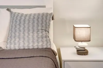 a bedroom with a bed and a lamp on a night stand at Ninho Gaivota in Porto Moniz