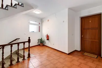 a hallway with a staircase and a wooden door at Ninho Gaivota in Porto Moniz