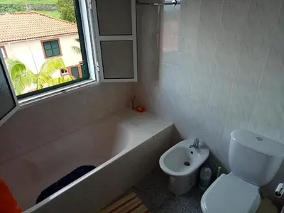 a bathroom with a tub and a toilet and a sink at Scenic Comfort in Ponta Delgada
