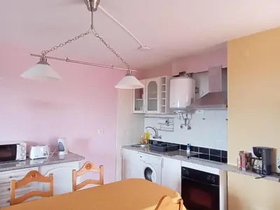 a kitchen with white cabinets and a table at Scenic Comfort in Ponta Delgada