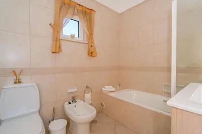 a bathroom with a toilet and a tub and a sink at Beautiful Villa on Boavista Golf Resort - Daily Service & Spa Access in Lagos
