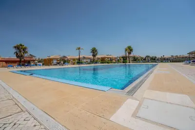 a swimming pool in a resort with palm trees at Beautiful Villa on Boavista Golf Resort - Daily Service & Spa Access in Lagos