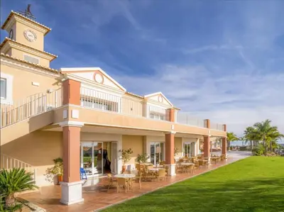 a large building with a clock tower on top of it at Beautiful Villa on Boavista Golf Resort - Daily Service & Spa Access in Lagos