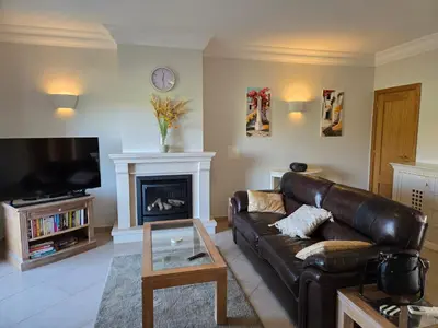 a living room with a leather couch and a fireplace at Beautiful Villa on Boavista Golf Resort - Daily Service & Spa Access in Lagos