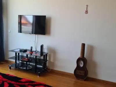 a room with a television and a table with a guitar at Machico Comfort in Machico