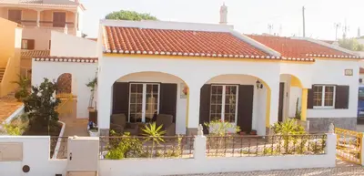 a white house with black shutters at LemonTree Eco Surfhouse in Sagres