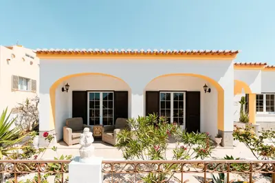 a villa with black shutters and a garden at LemonTree Eco Surfhouse in Sagres