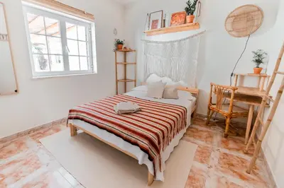 a bedroom with a bed with a striped blanket at LemonTree Eco Surfhouse in Sagres