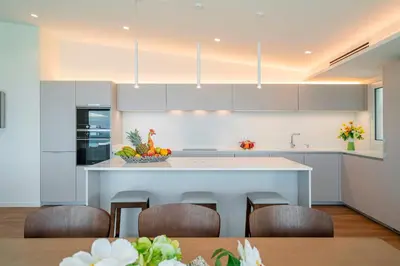 a kitchen with a large island with chairs in it at OurMadeira - GrandView in Funchal