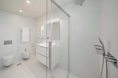 a white bathroom with a toilet and a glass shower at OurMadeira - GrandView in Funchal